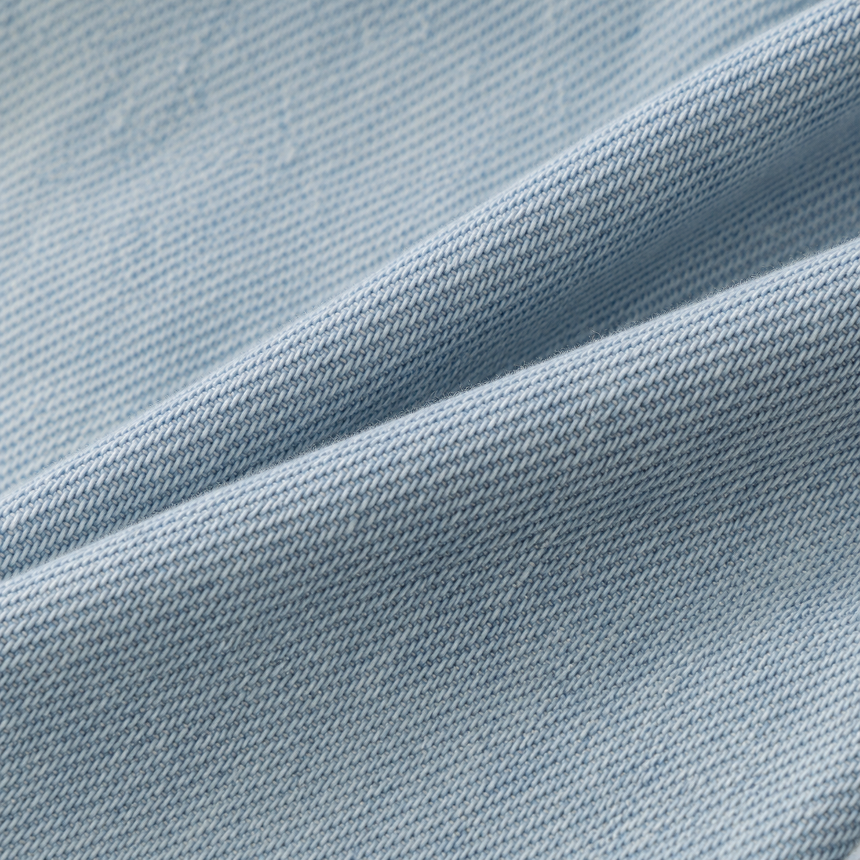 Close-up of soft light blue denim fabric texture.