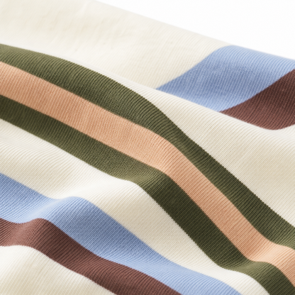 Close-up of the cream cotton-blend knit fabric with blue, brown, olive and blush stripes.