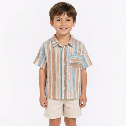 Boy model wearing pastel stripe boys shirt and shorts set on a white background.