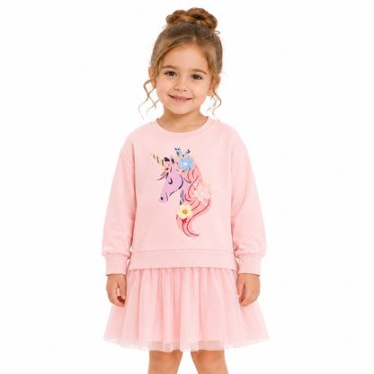 Girl model wearing a pink long sleeve cotton unicorn dress on a white studio background.