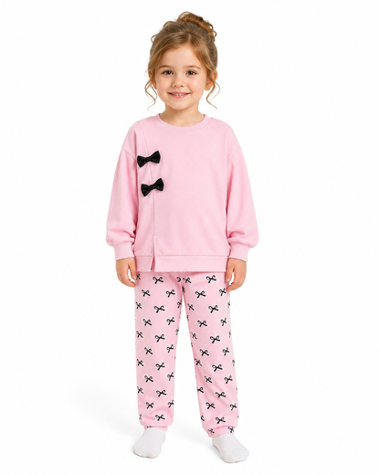 Girl model wearing a pink girls matching lounge set on a white studio background.