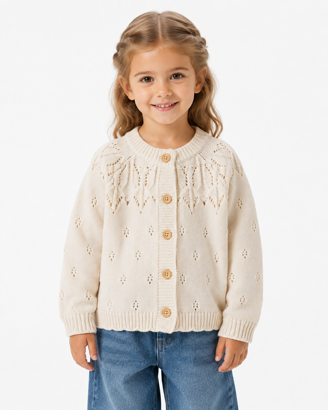 Girl wearing the cream cotton knit cardigan with an openwork yoke and button front on a white studio background.