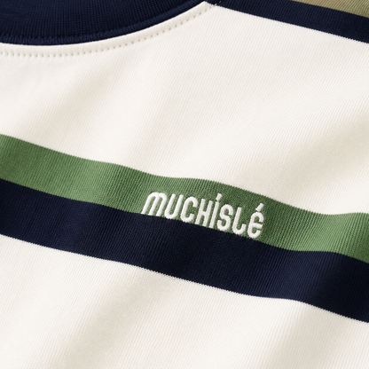 Close-up of the small white embroidered chest detail on the white, navy and green striped T-shirt.