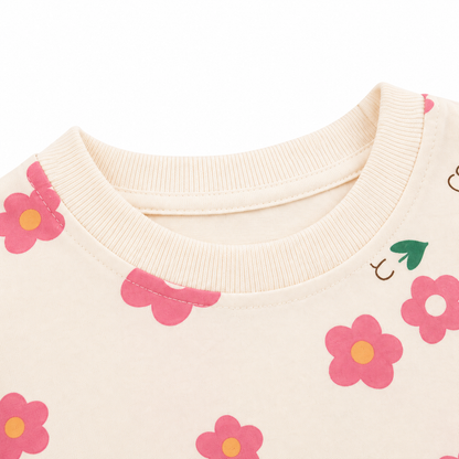 Close-up of the round ribbed neckline on a cream floral girls cotton t shirt.