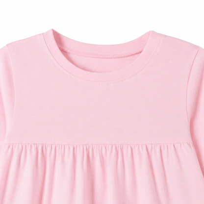 Close-up of the crew neckline and gathered seam on the pink girls cotton top.