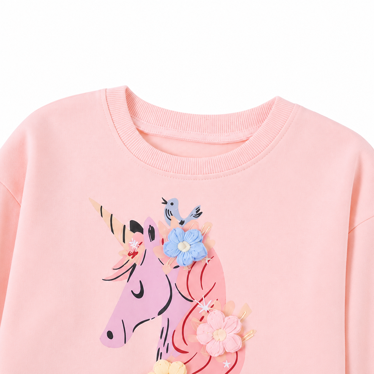 Close-up of the neckline and upper unicorn applique detail on a pink girls dress.