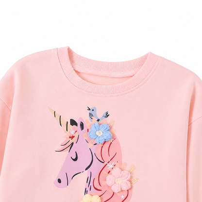 Close-up of the neckline and upper unicorn applique detail on a pink girls dress.