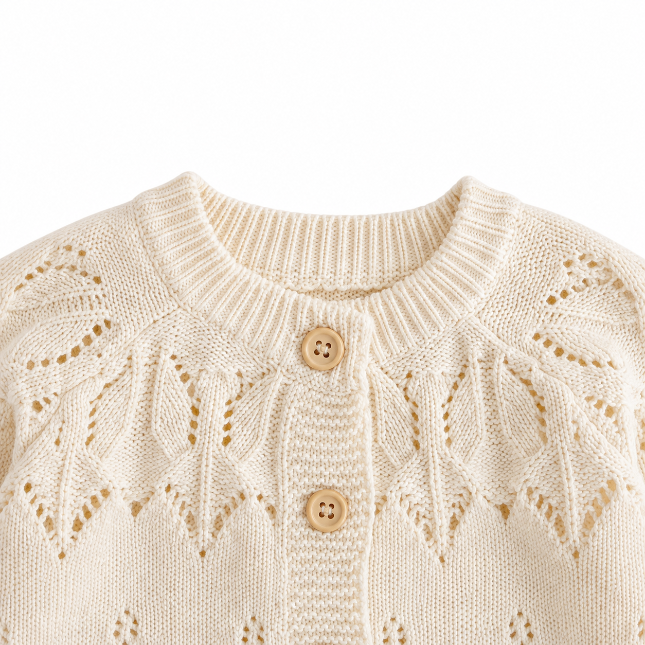 Close-up of the round ribbed neckline, cream button placket and openwork knit yoke on the girls cardigan.