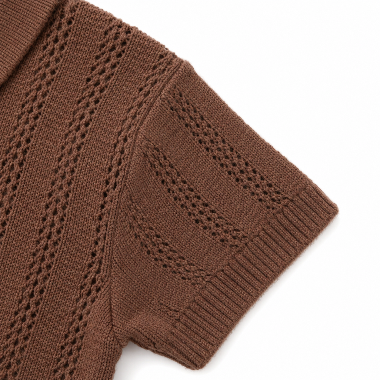 Close-up of the short sleeve, ribbed cuff and openwork knit pattern on the brown boys polo.