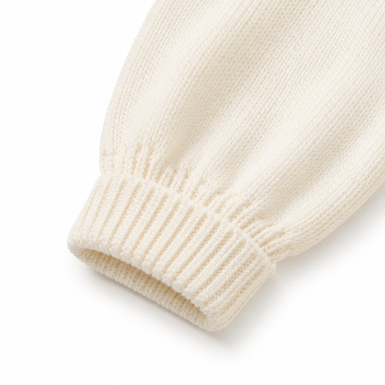 Close-up of the long sleeve and ribbed cuff on the cream girls cotton knit cardigan.