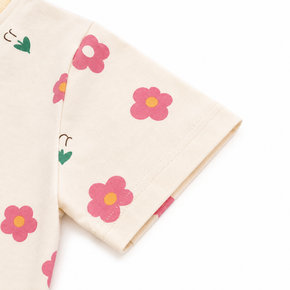 Close-up of the short sleeve hem detail on a cream floral girls tee.