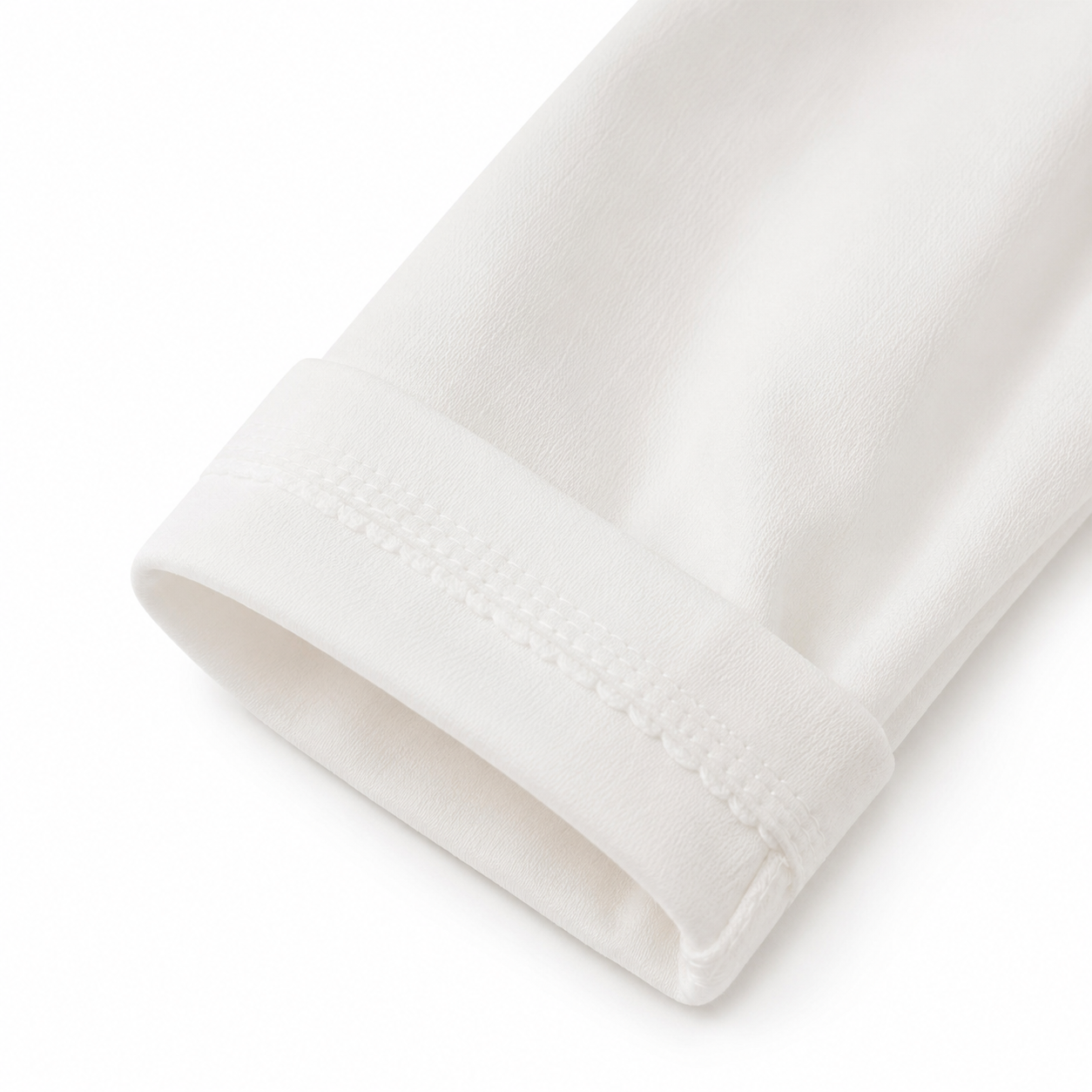 Close-up of the sleeve cuff detail on a white girls cotton top.