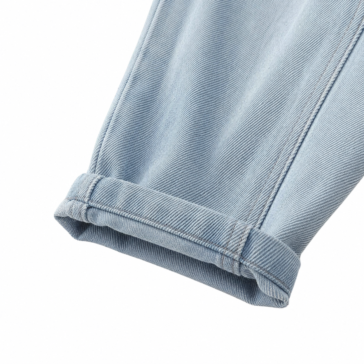 Close-up of rolled cuff detail on boys light blue denim joggers.