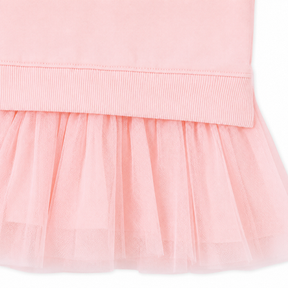 Close-up of the waist seam and gathered tulle skirt detail on a pink girls dress.