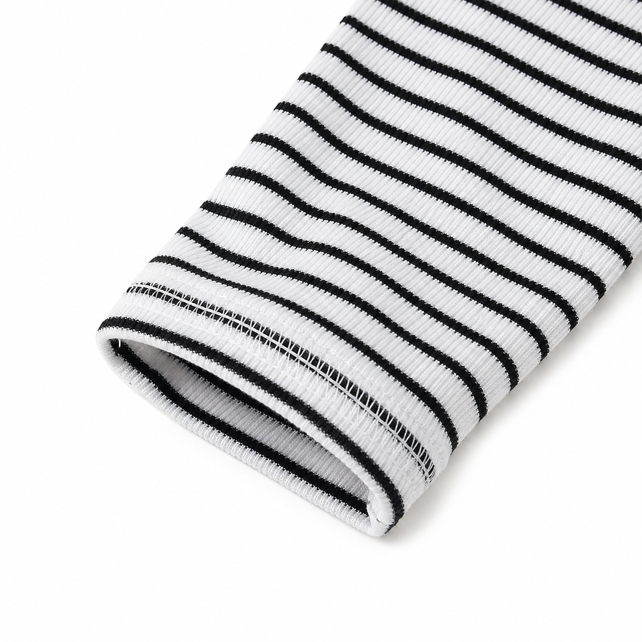 Close-up of the long sleeve cuff and fine stripe pattern on a girls black and white top.