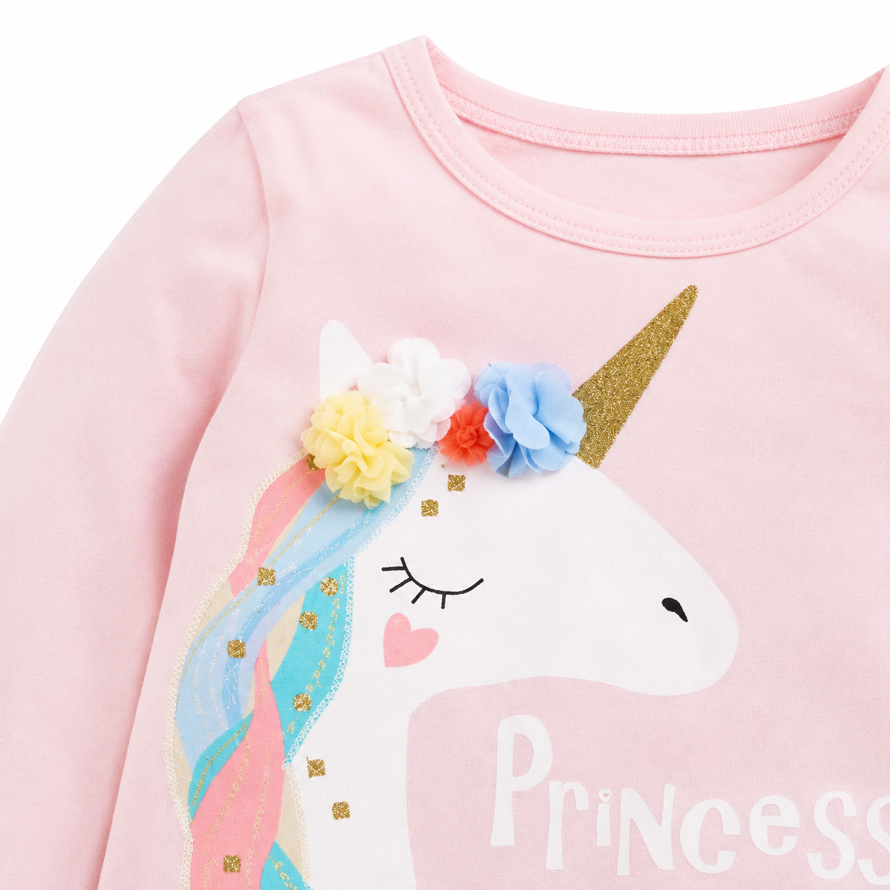 Close-up of the unicorn graphic and floral applique detail on the front of the girls top.