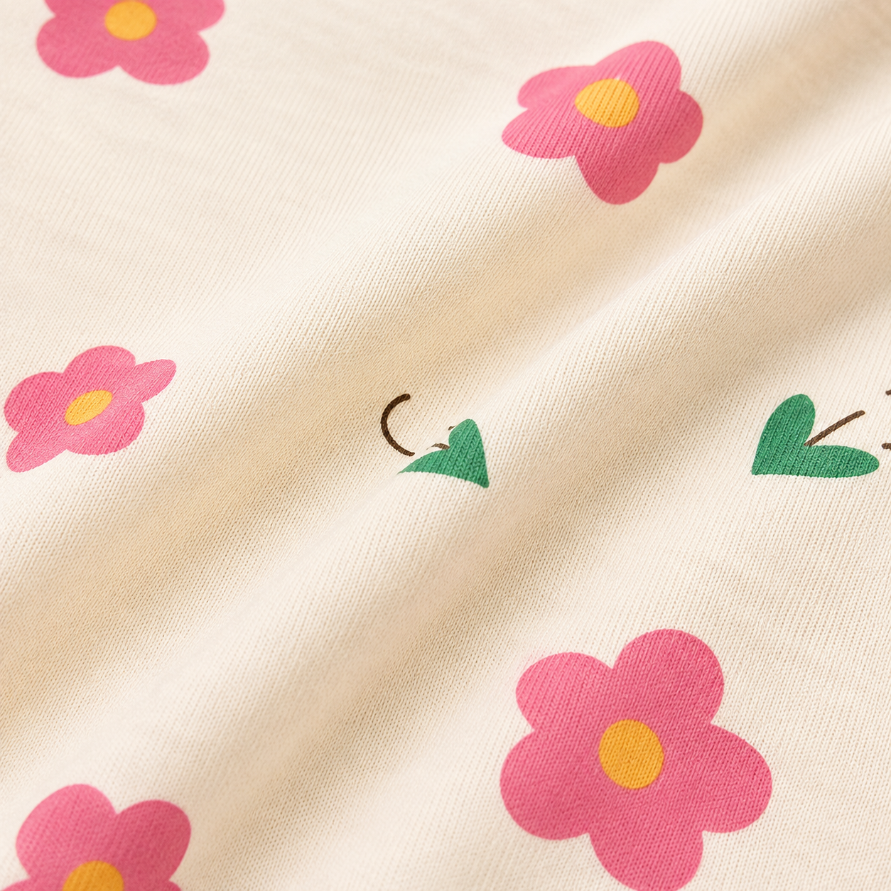 Close-up of the cotton fabric texture on a cream floral girls t shirt.