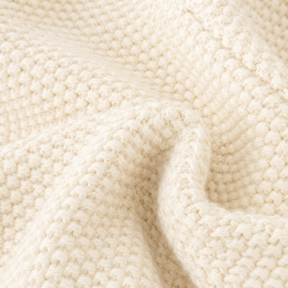 Close-up of the cotton knit fabric texture on a cream girls cardigan.
