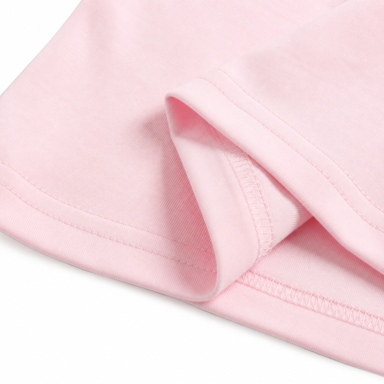Close-up of the pink cotton fabric texture on the girls long sleeve top.