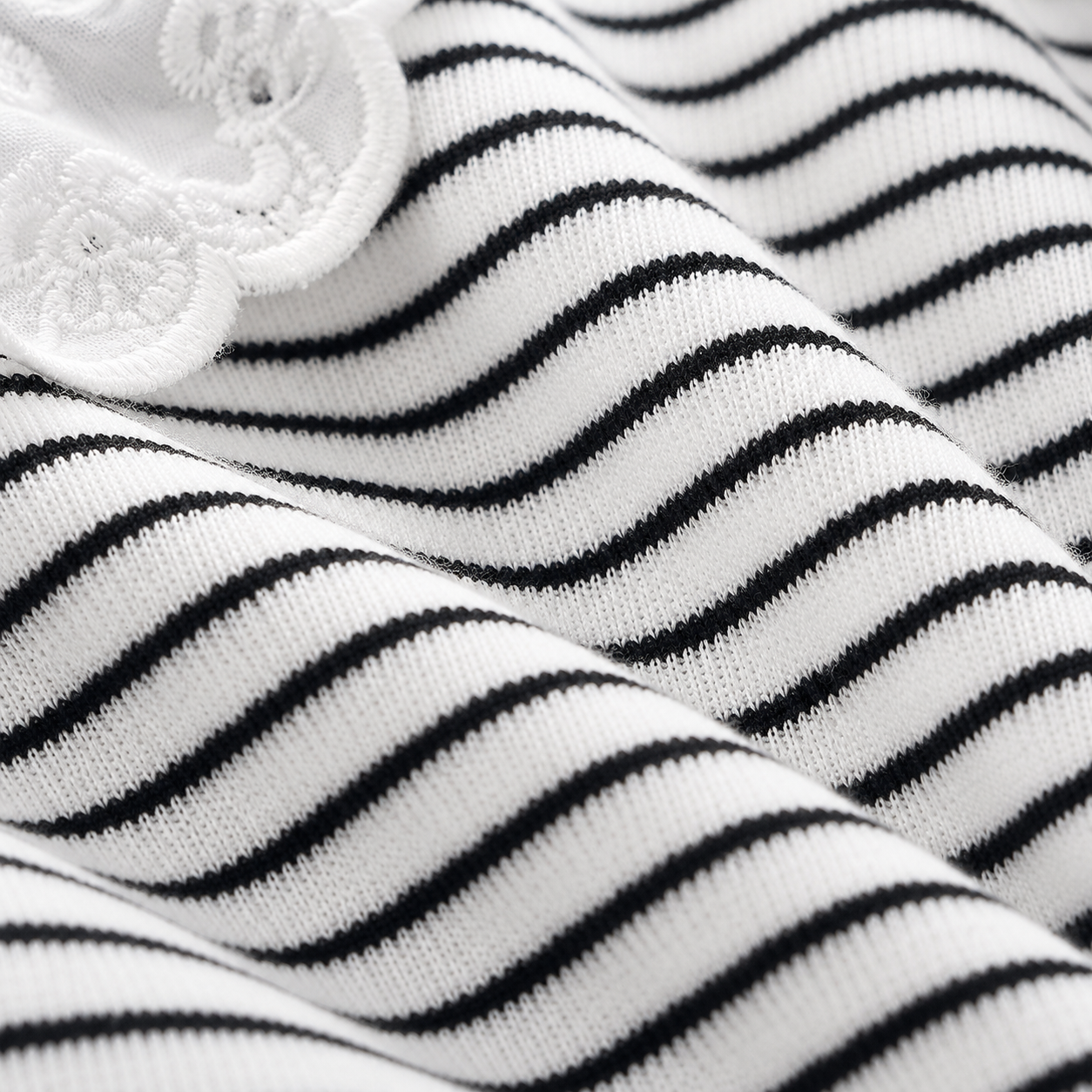 Close-up of the black and white striped fabric texture on a girls long sleeve top.