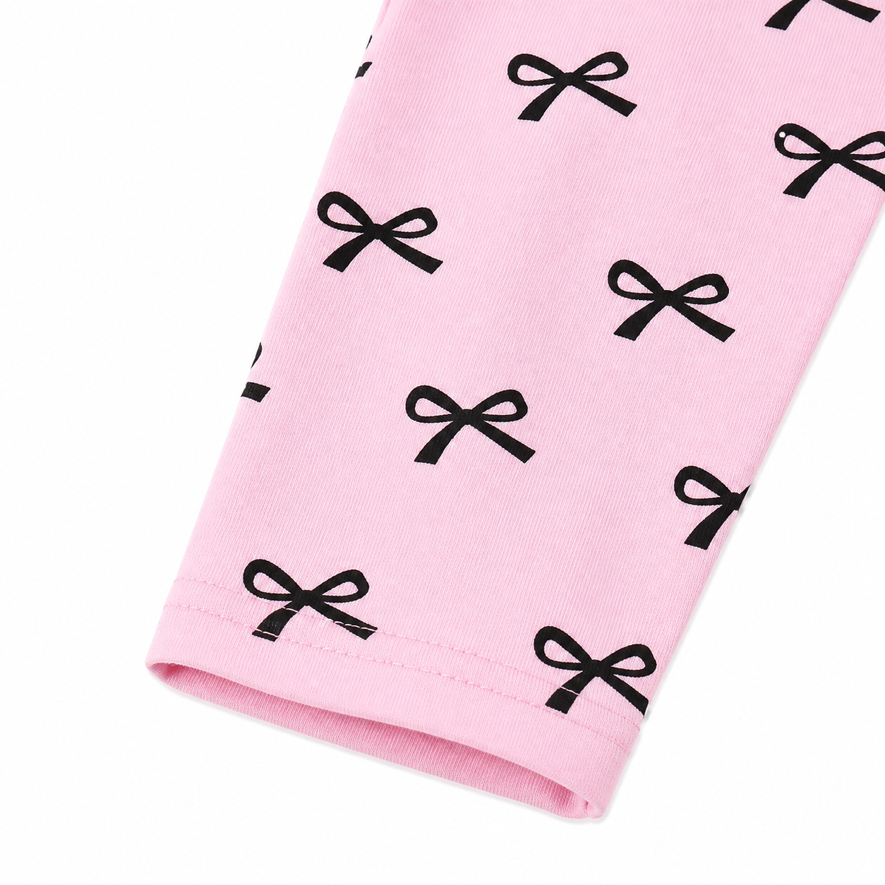 Close-up of the black bow print detail on the pink pants.