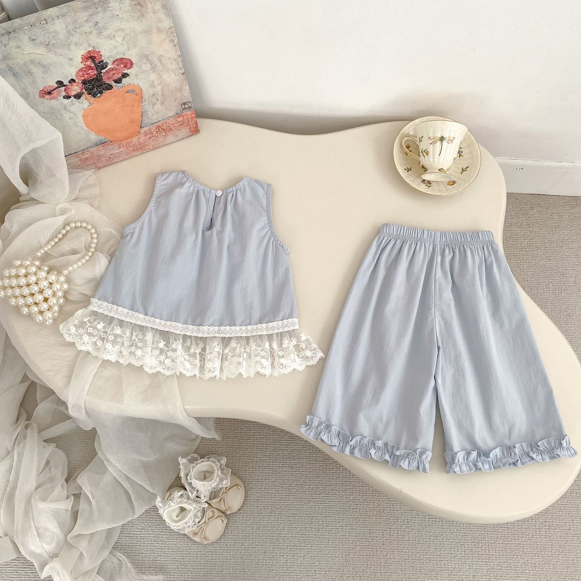 Back view of the Bluebell Lace Set in light blue with a button-back top and elastic waist pants.