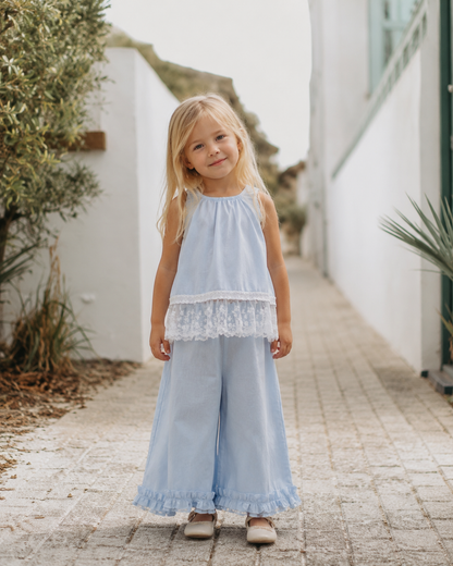 Young girl wearing the Bluebell Lace Set in light blue with a lace-trim top and wide-leg pants.