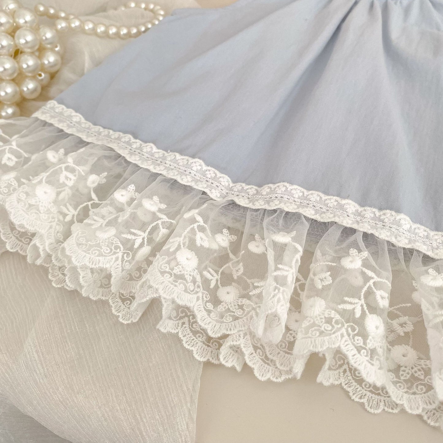 Close-up of the Bluebell Lace Set lace trim detail on the light blue sleeveless top.