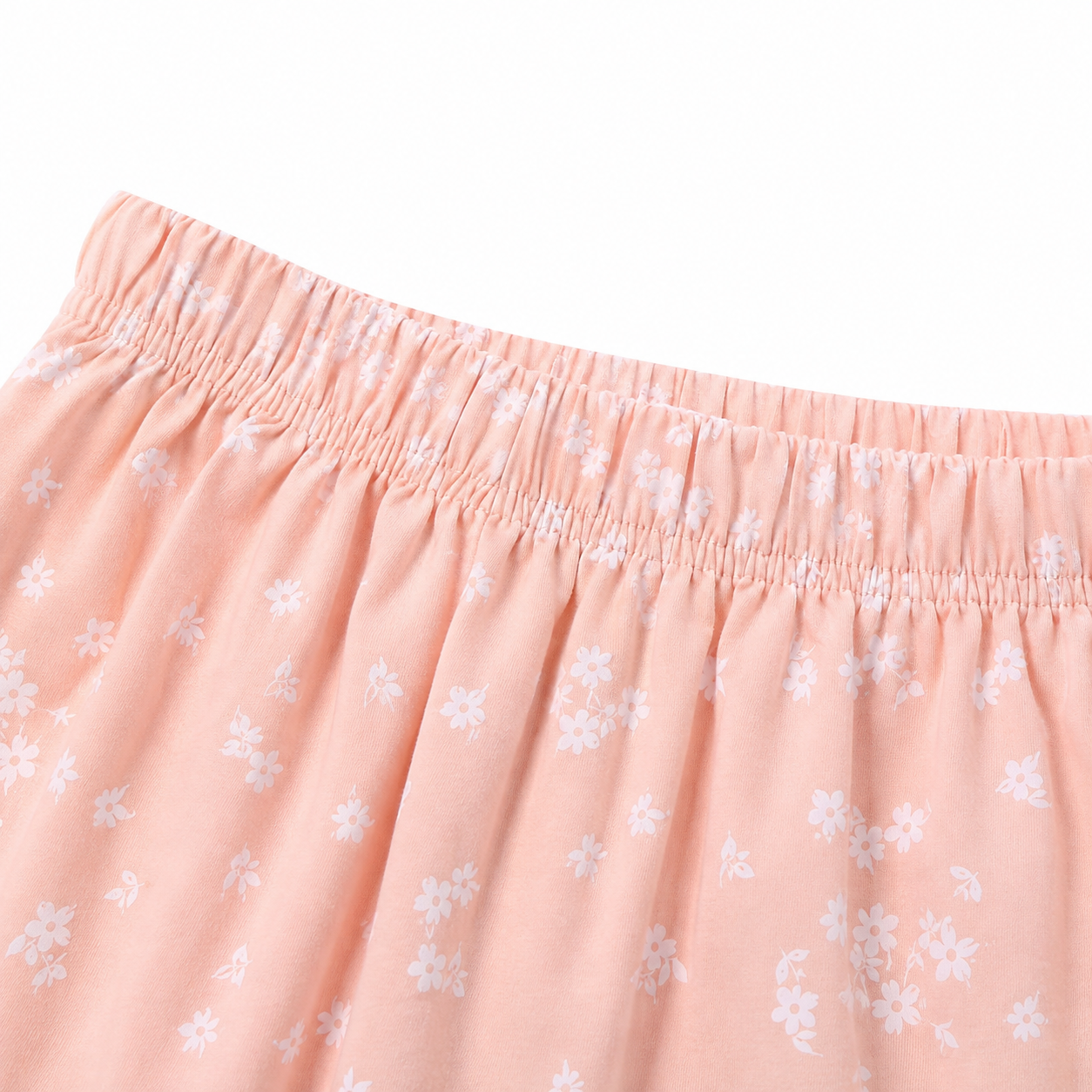 Close-up of the elastic waistband and small floral print on the blush pink shorts.