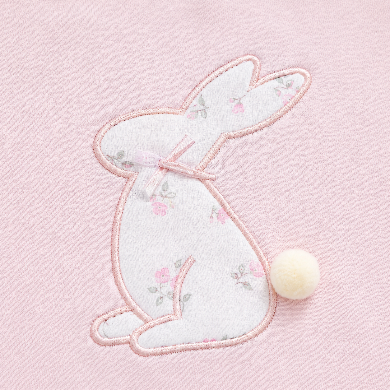 Close-up of the bunny embroidery with a small pom-pom tail detail on the Blush Pink girls cotton long sleeve top.