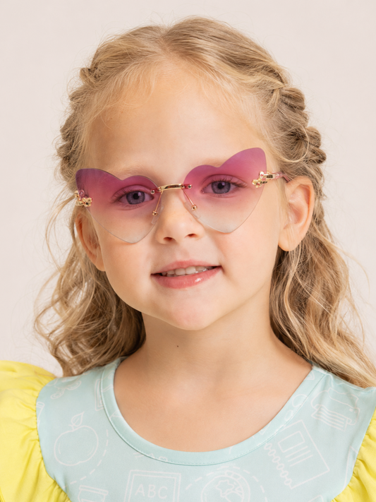 Little girl wearing pink heart sunglasses with UV400 lenses