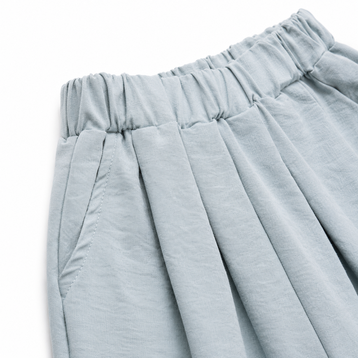 Close-up of the pleated elastic waistband on the dusty blue culotte pants.