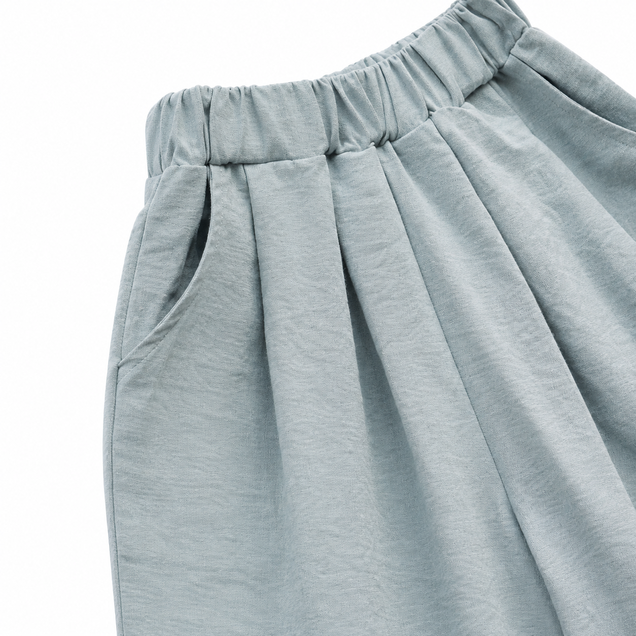 Close-up of the side pocket and wide-leg shape on the dusty blue pants.