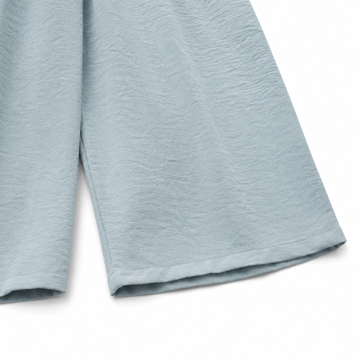 Close-up of the fabric texture and hem on the dusty blue culotte pants.