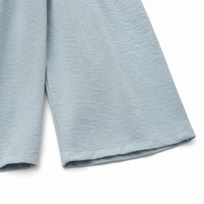 Close-up of the fabric texture and hem on the dusty blue culotte pants.