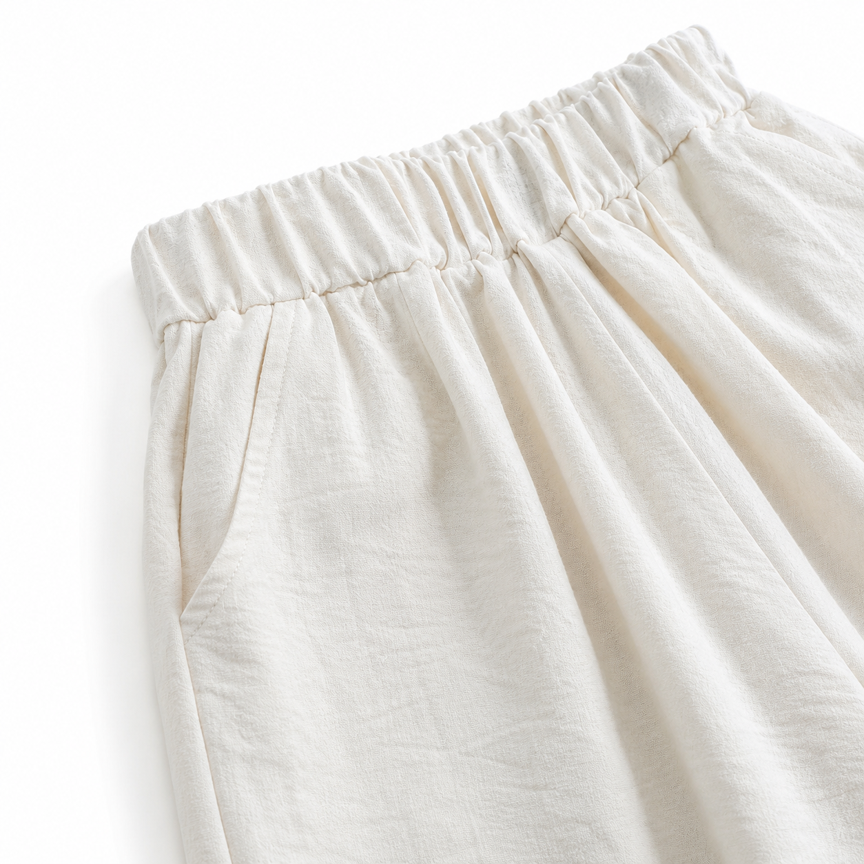 Close-up of the pleated elastic waistband on the ivory culotte pants.