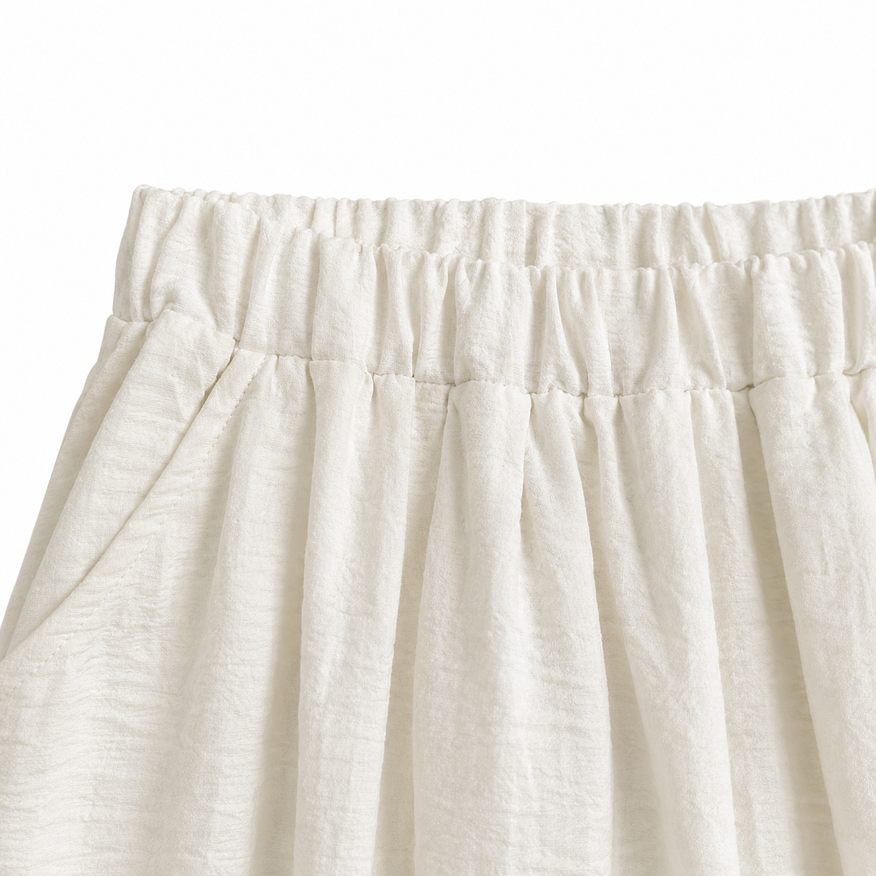 Close-up of the elastic waist construction on the ivory girls pants.