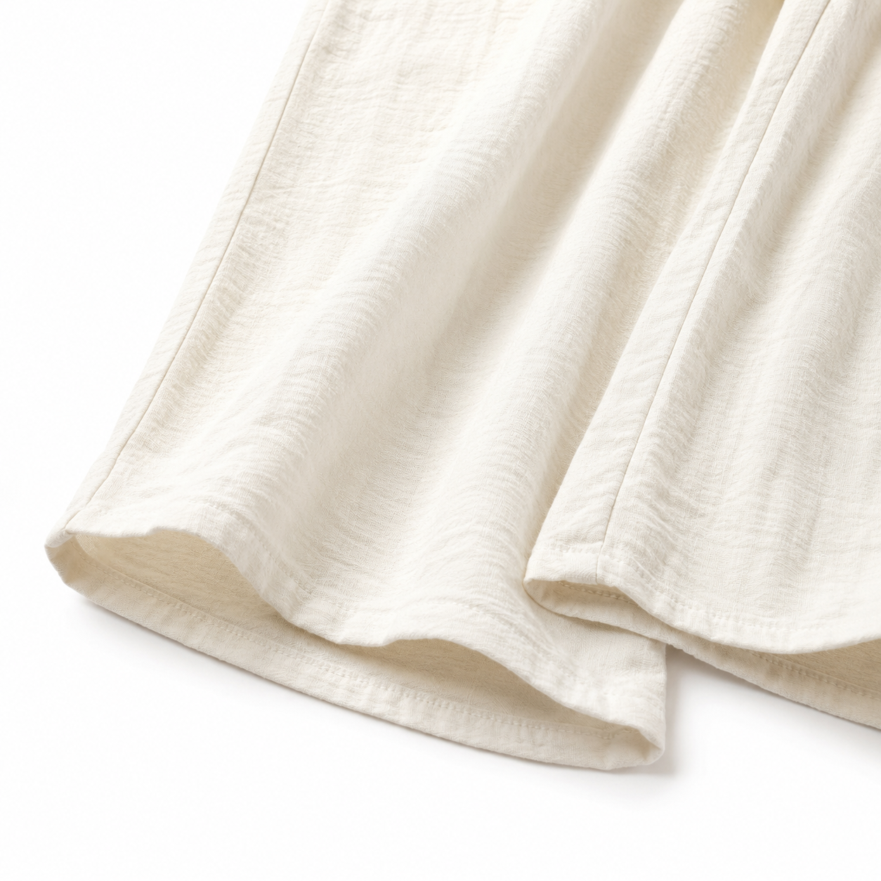 Close-up of the fabric texture and hem on the ivory culotte pants.