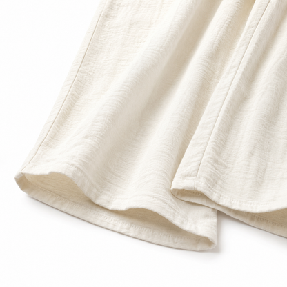 Close-up of the fabric texture and hem on the ivory culotte pants.