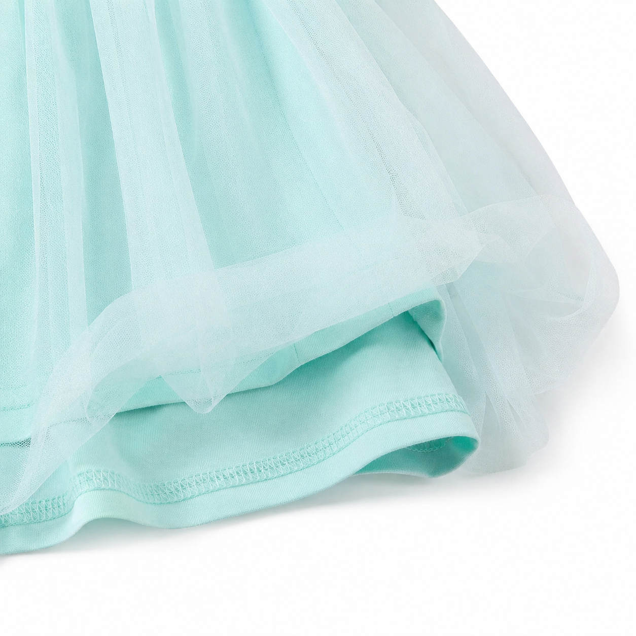 Close-up of the mint green tulle skirt layer and gathered dress texture.