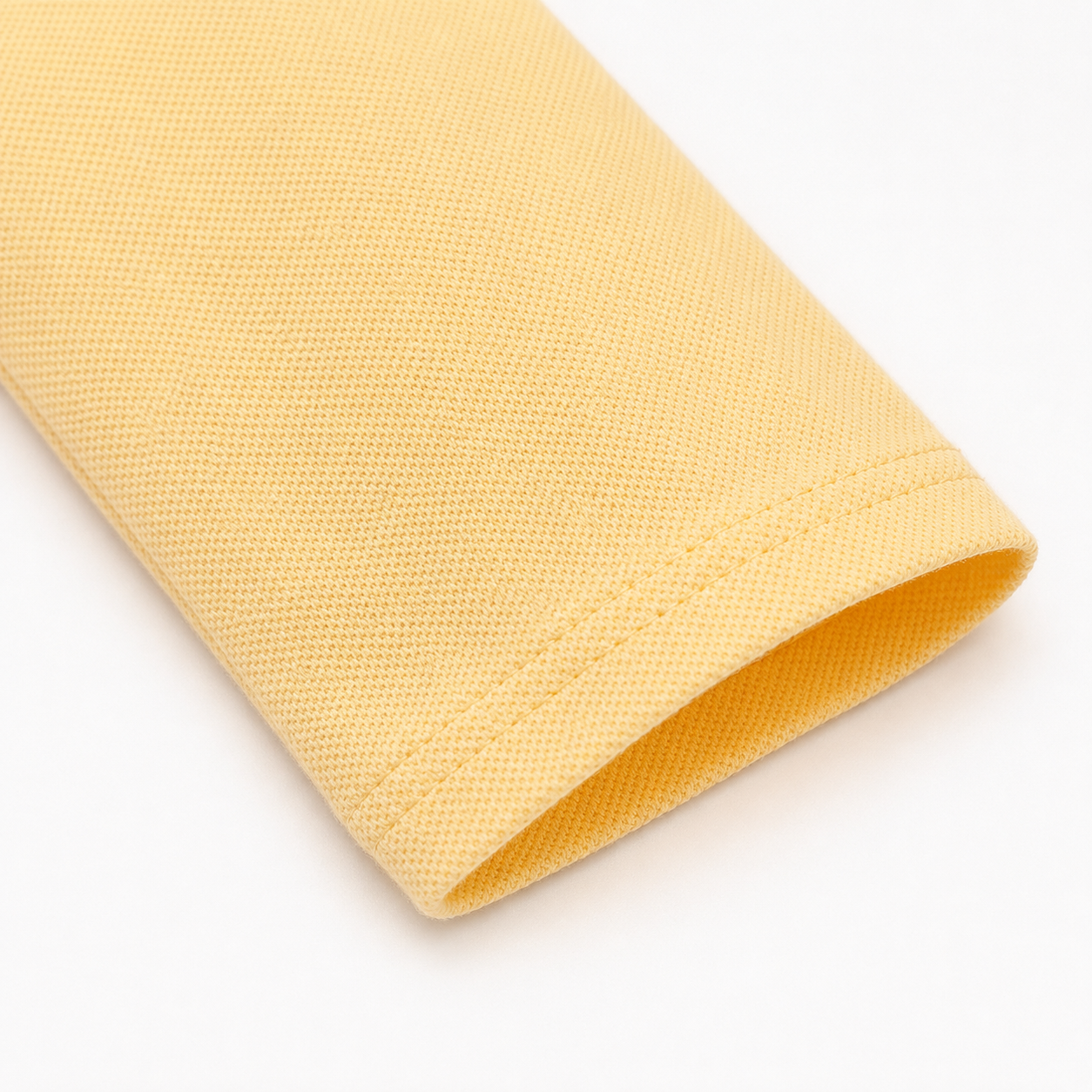 Close-up of the long sleeve and cotton-blend fabric on the butter yellow kids polo.