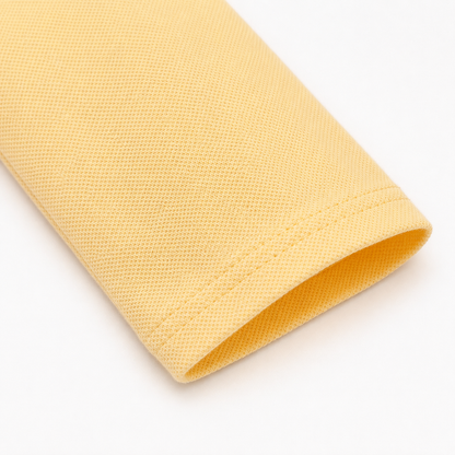 Close-up of the long sleeve and cotton-blend fabric on the butter yellow kids polo.