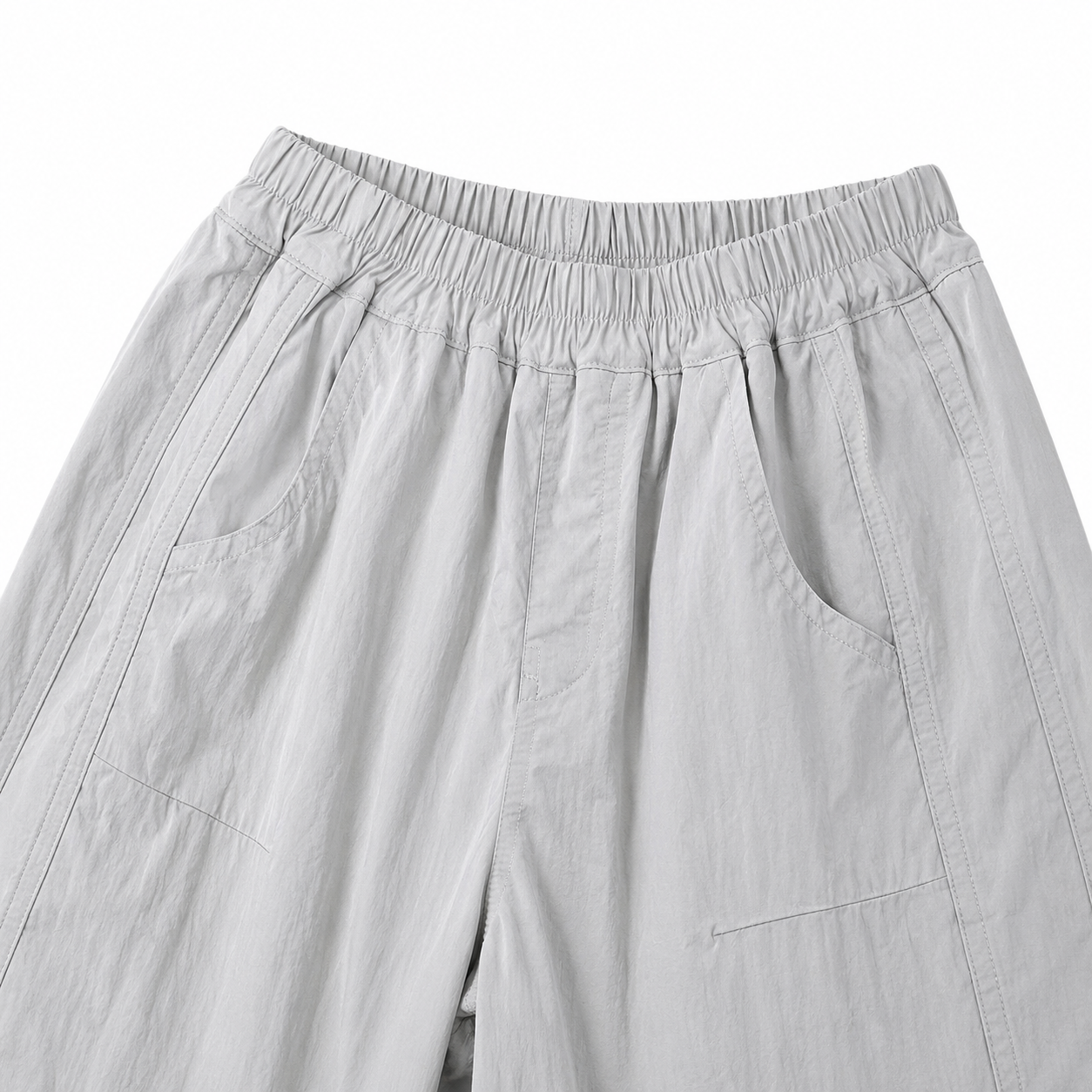 Close-up of the light gray kids pants elastic waist and front side pockets.