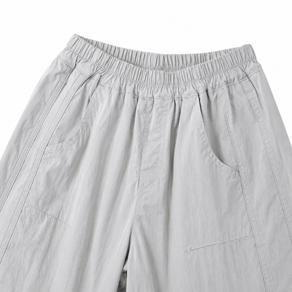 Close-up of the light gray kids pants elastic waist and front side pockets.