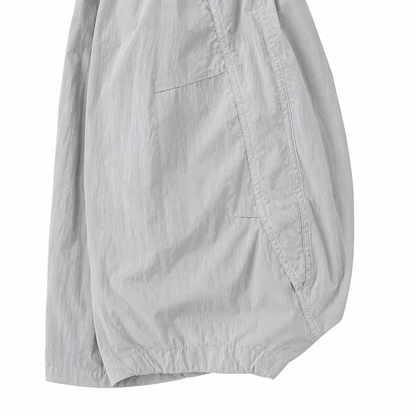 Close-up of the curved side seam and relaxed balloon-leg shape of the light gray kids pants.