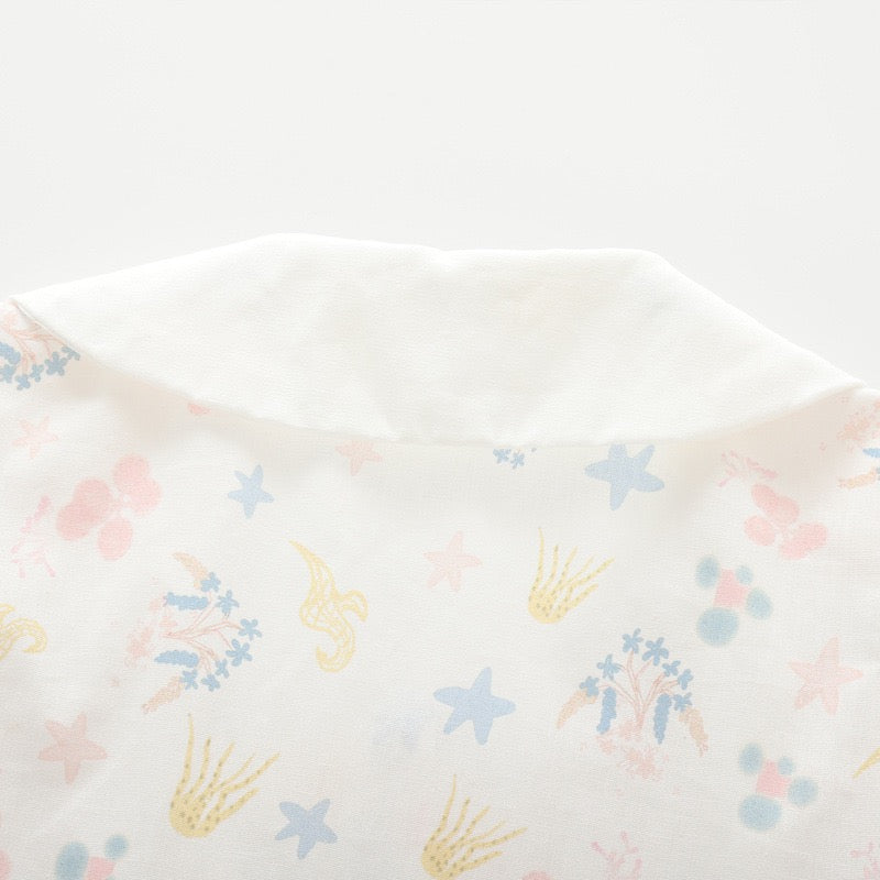 Close-up of the pastel sea life and floral print on the back of the white girls blouse.
