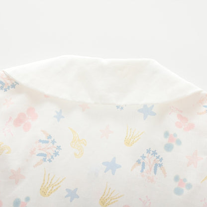 Close-up of the pastel sea life and floral print on the back of the white girls blouse.