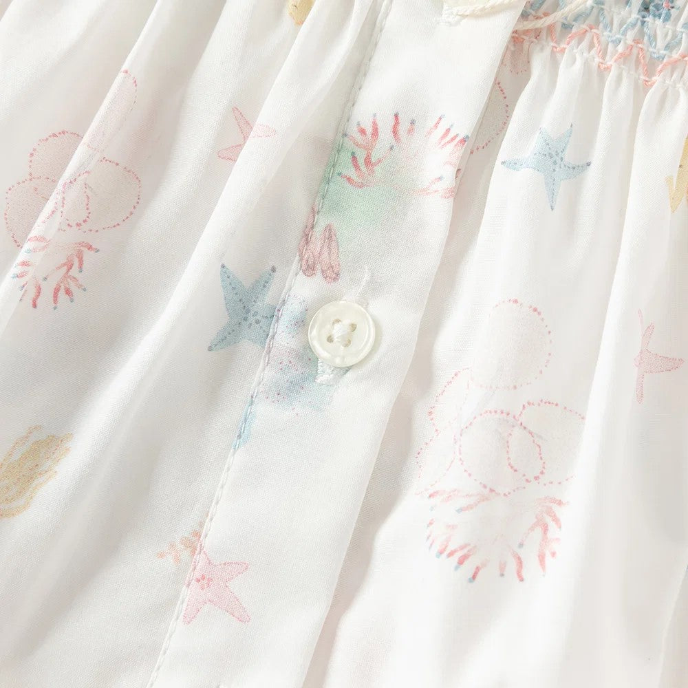Close-up of the front button opening with starfish, shell, coral and seahorse print.