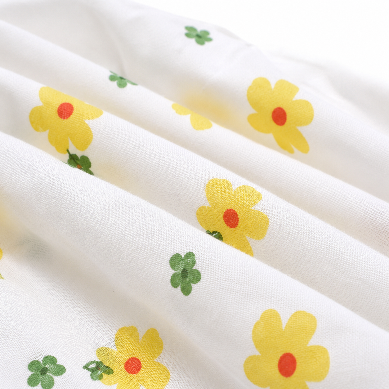 Close-up of the yellow and green floral print on the cotton fabric.