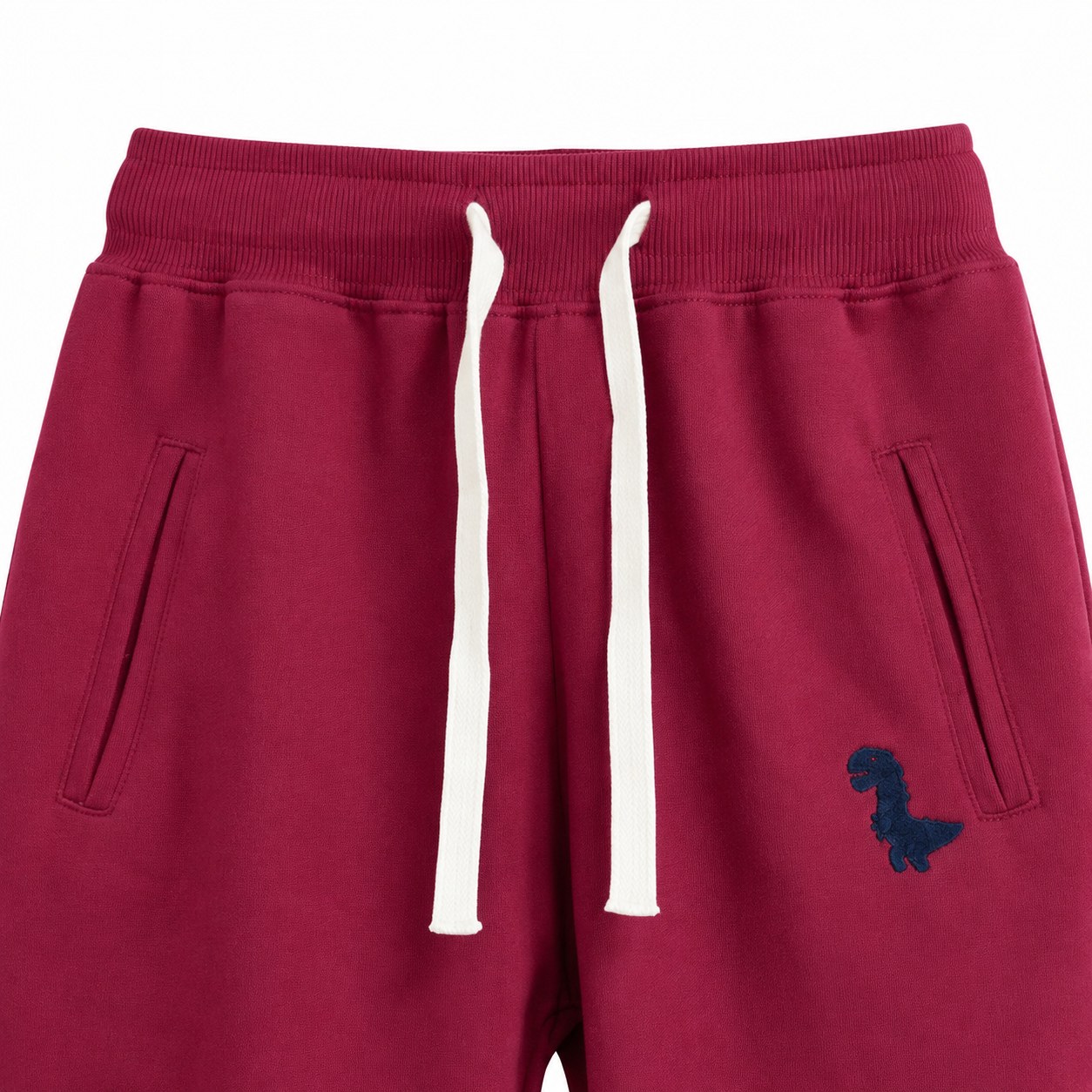 Close-up of the waistband, drawstring, pockets, and knee seam detail on the burgundy kids joggers.